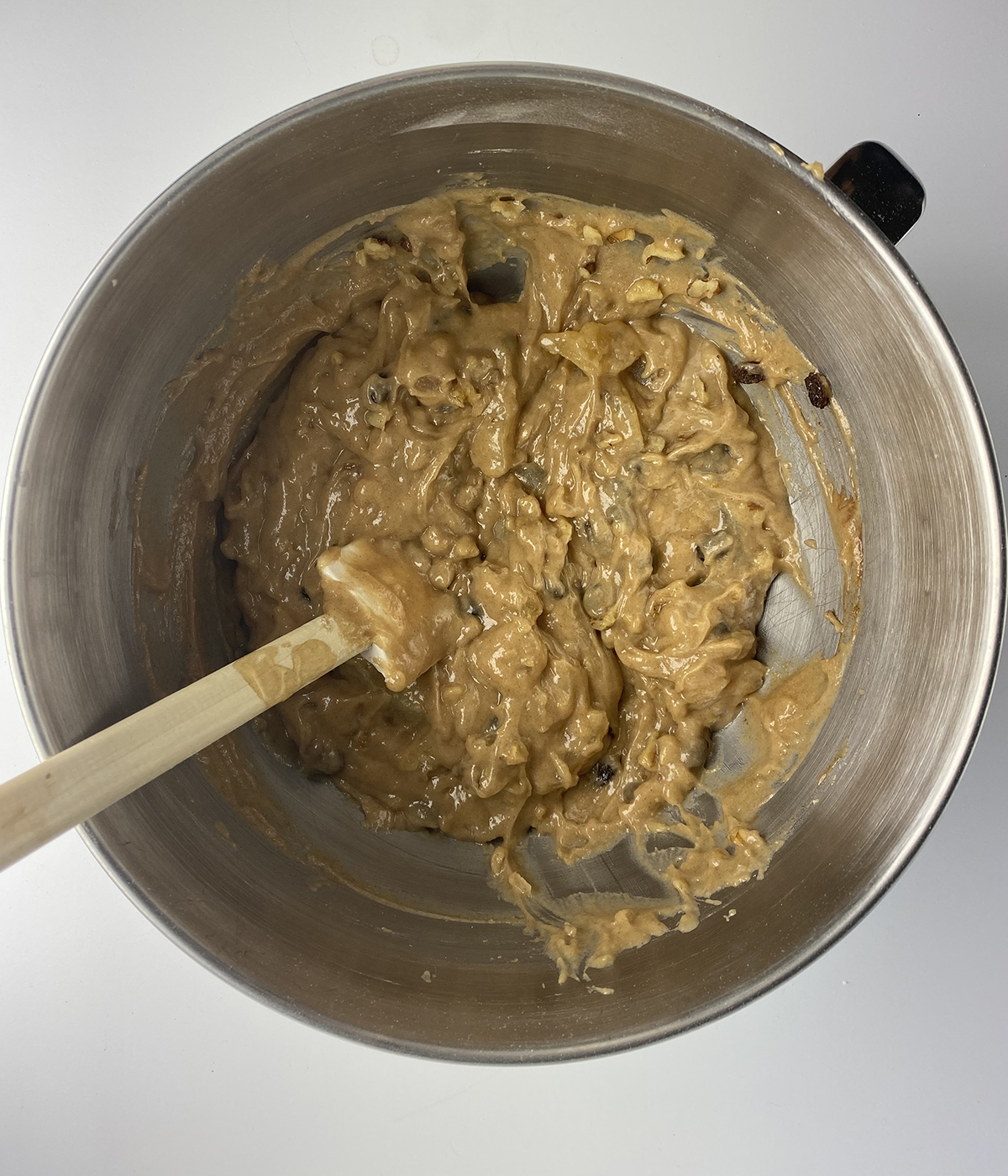 Mixing nuts and raisins into apple cake batter