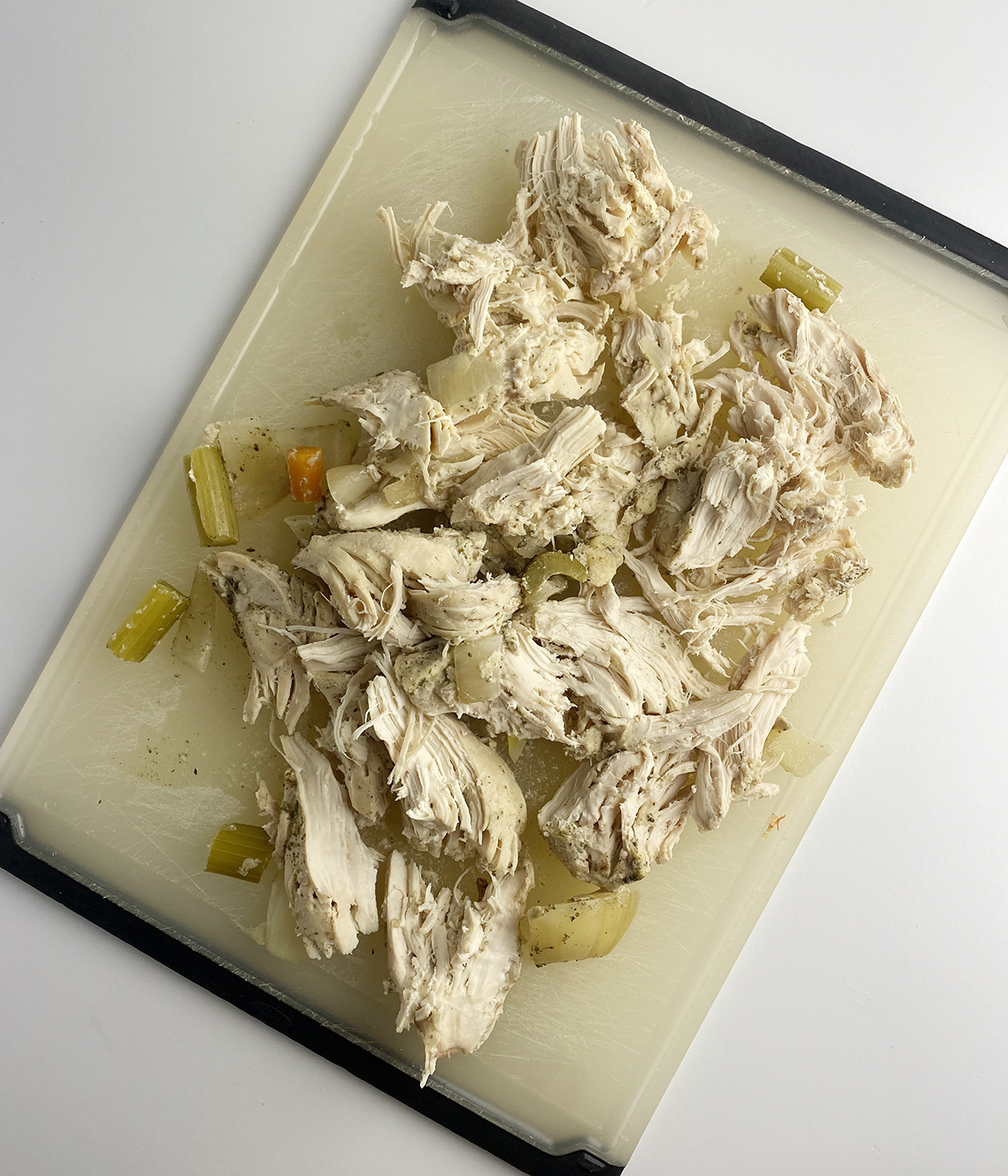 Shredded chicken on a cutting board.