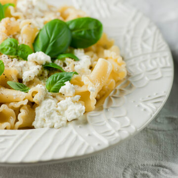 Basil ricotta macaroni and cheese on a plate.