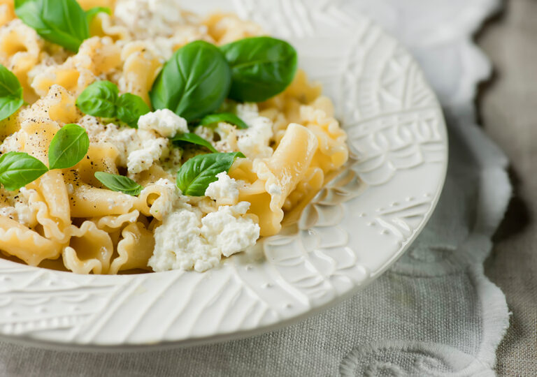Basil ricotta macaroni and cheese on a plate.
