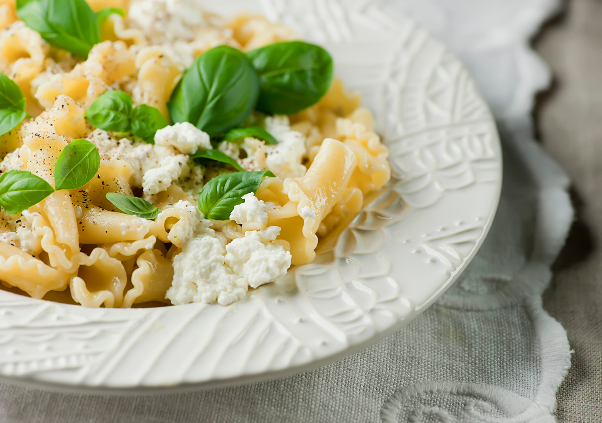 Basil ricotta macaroni and cheese on a plate.