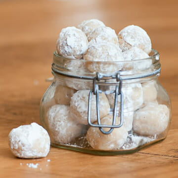 No Bake Rum Balls in a jar on a wooden surface.