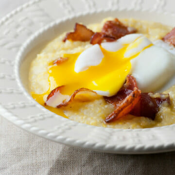 Eggs with creamy bacon grits in a bowl.