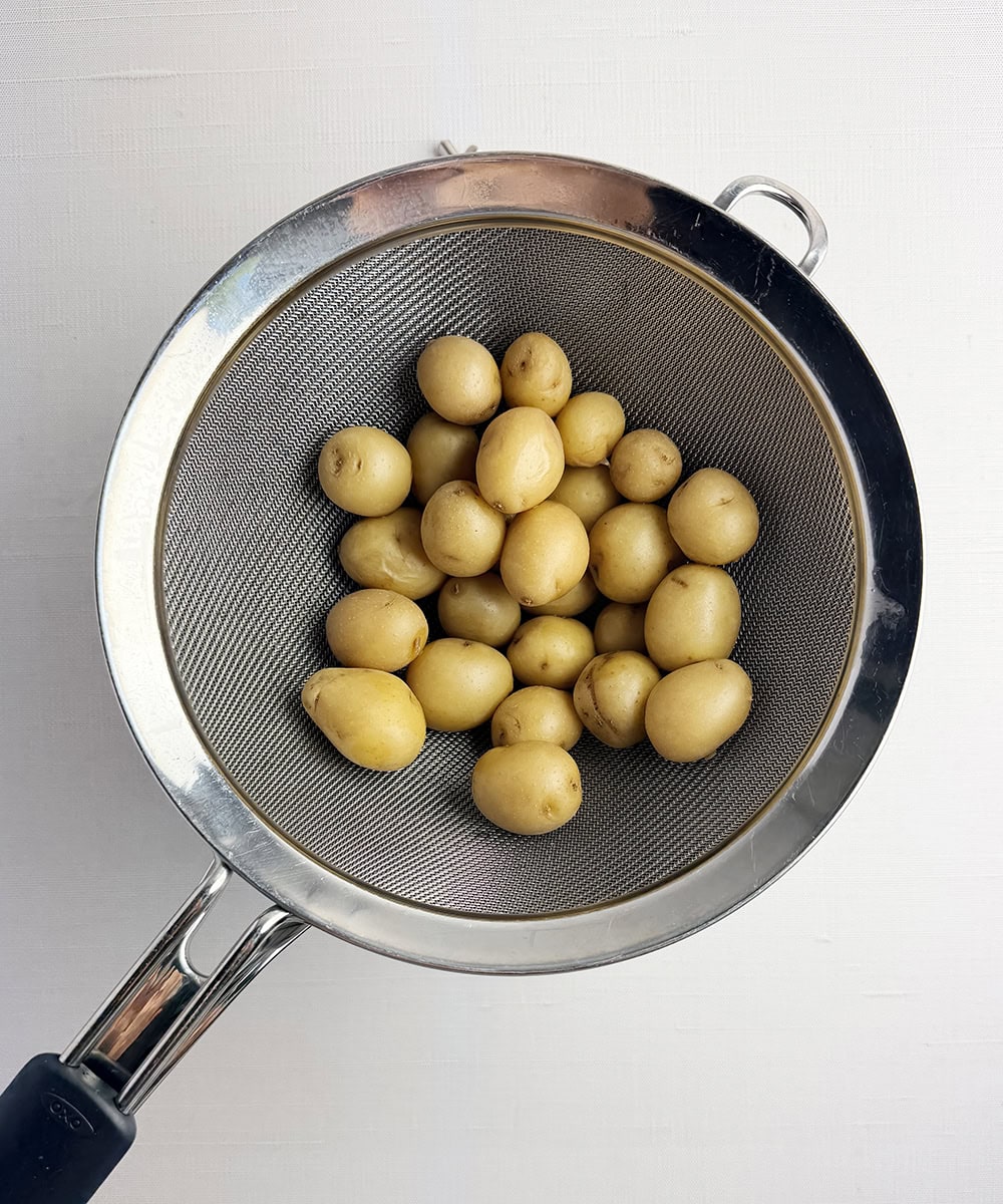 Baby potatoes draining in a strainer.