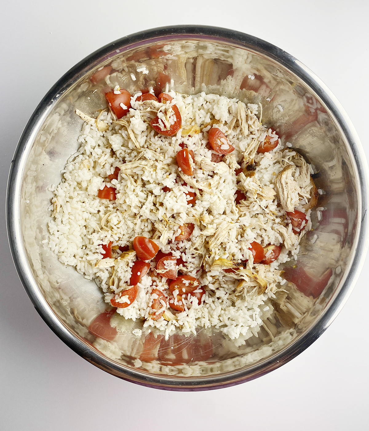 Chicken rice salad tossed in a bowl.