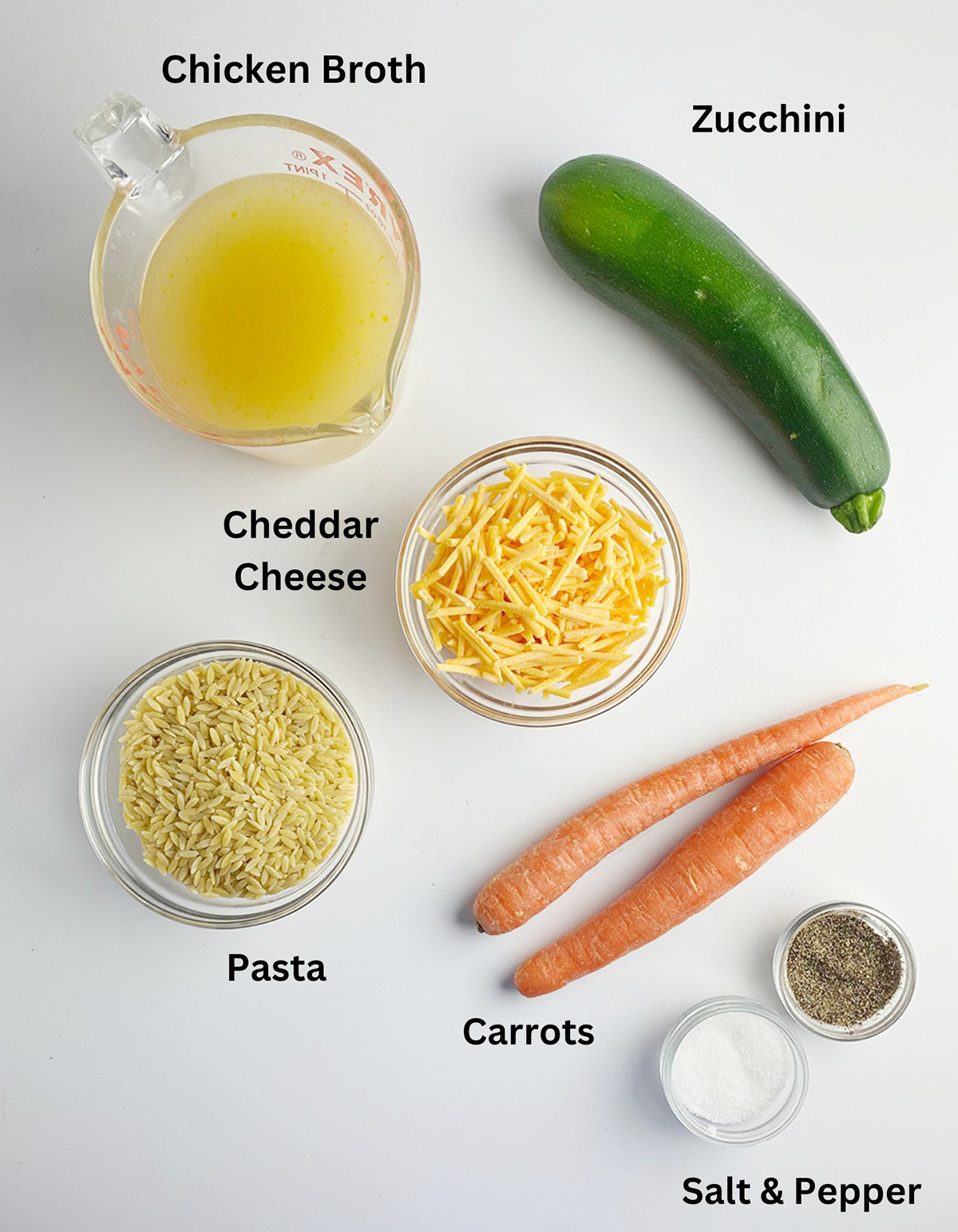 Ingredients for cheesy vegetable pasta on a counter.