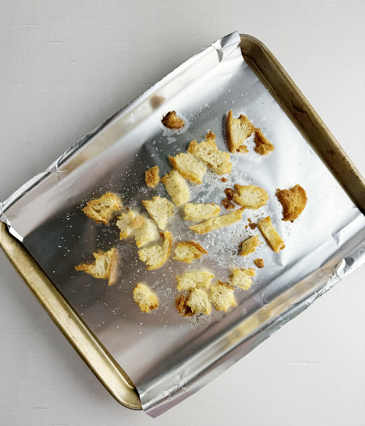 Toasted bread pieces on a baking pan.