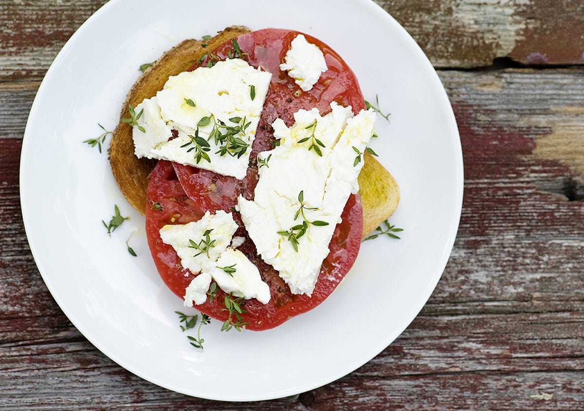 Tomato feta sandwich on a plate.