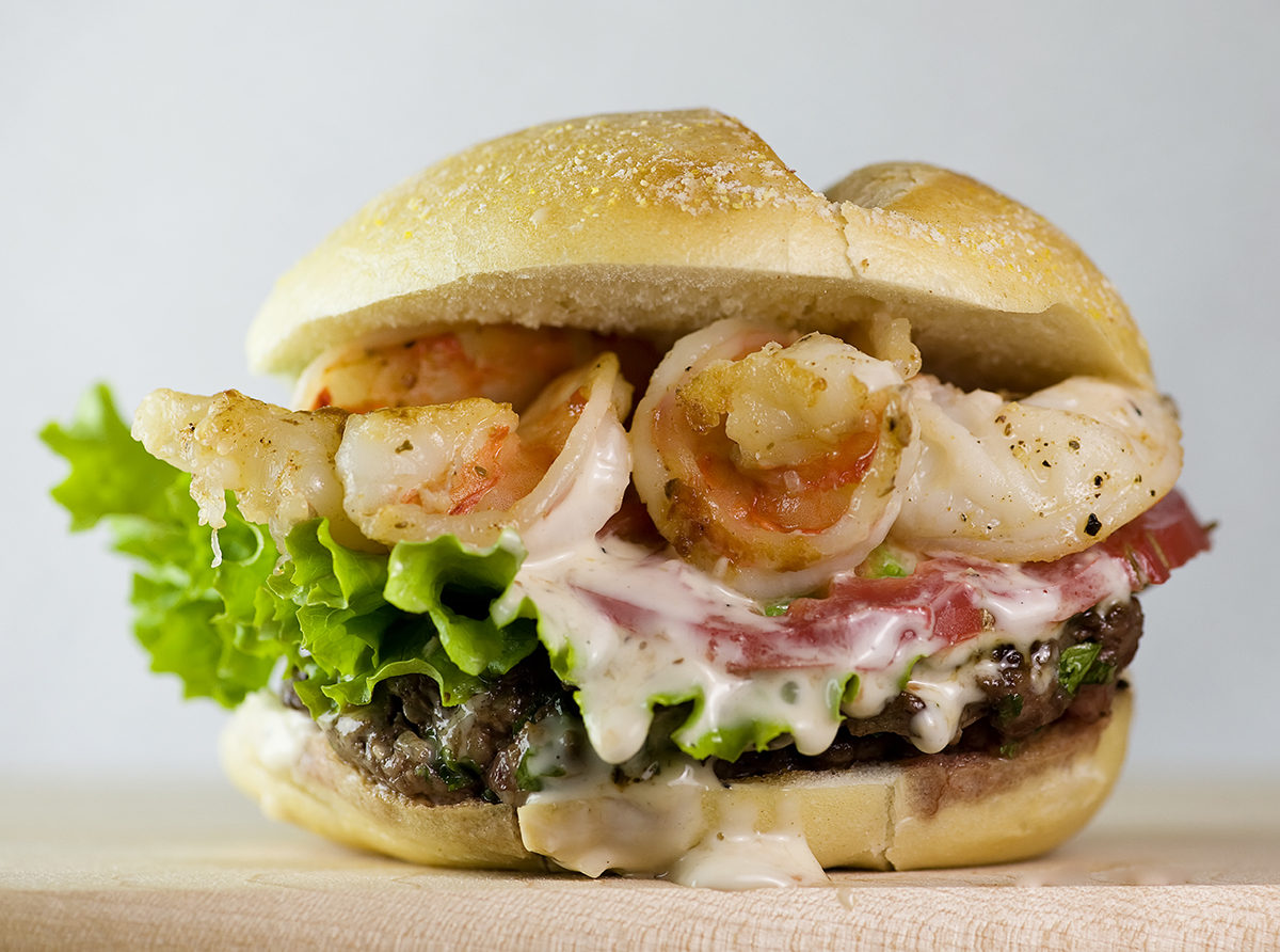 Surf and turf burger on a wooden board.