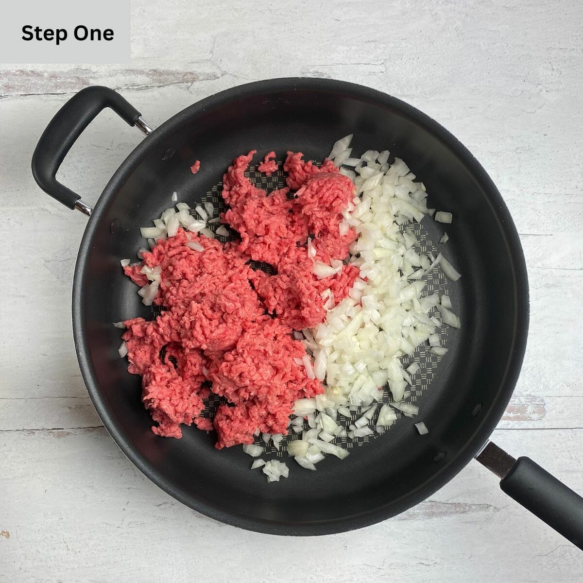 Cooking taco wrap meat in a skillet with some onions.