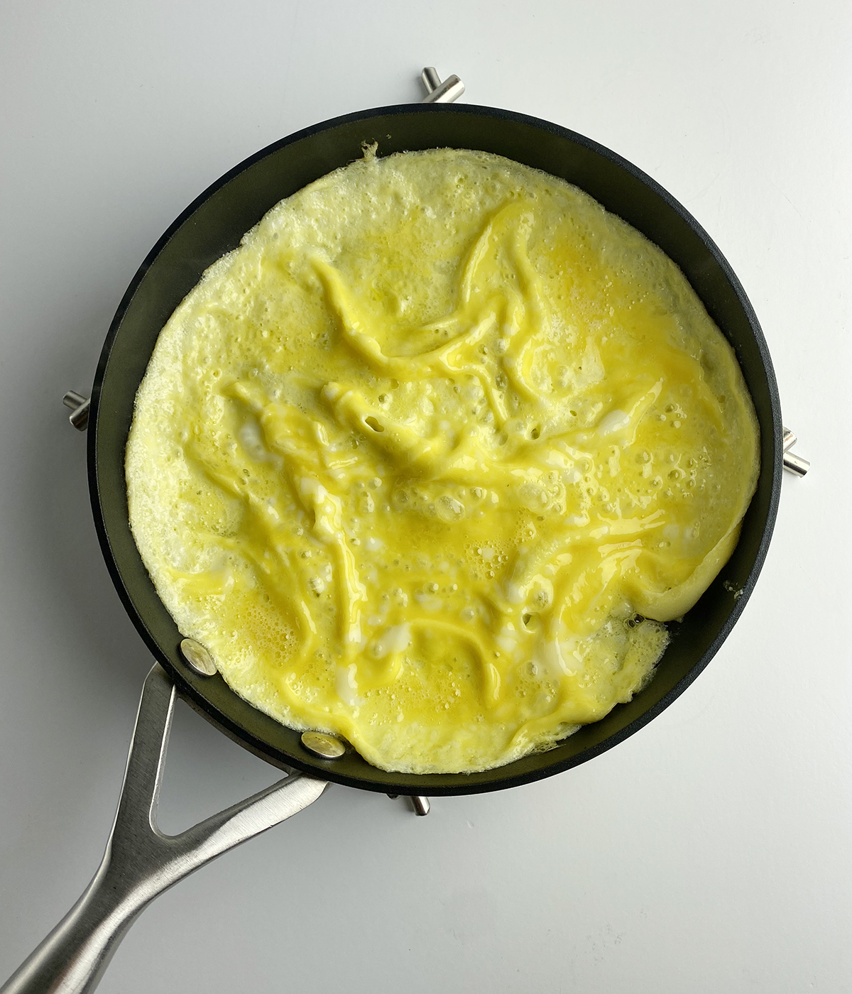Cooked Omelet in a skillet reading for filling.