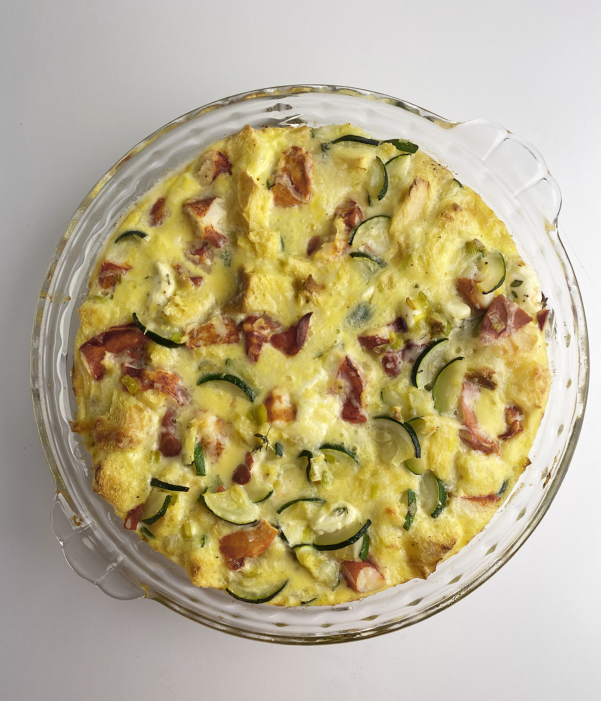 Fully baked lobster frittata in a pie plate.