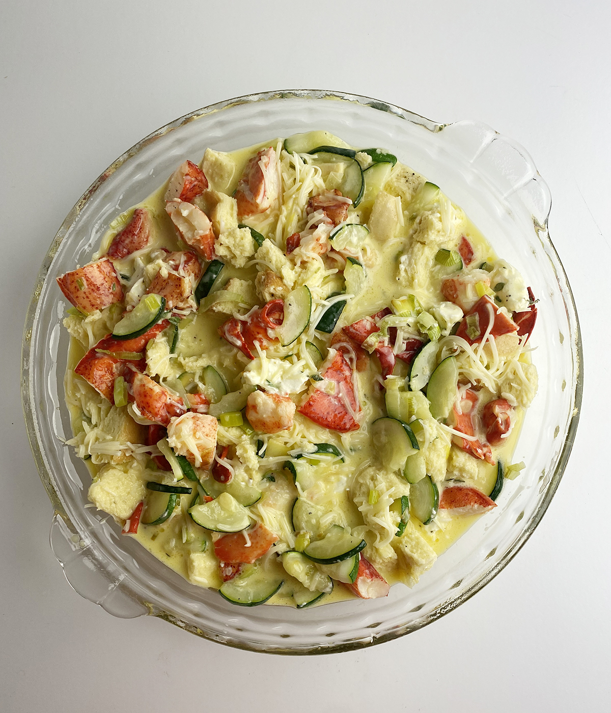 Lobster frittata mixture in a pie plate ready for the oven.