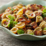 Pasta with tomato Bacon sauce in a dish.
