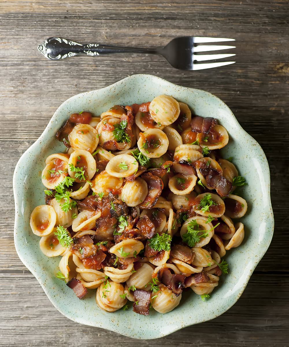 Pasta with tomato bacon sauce in a bowl.