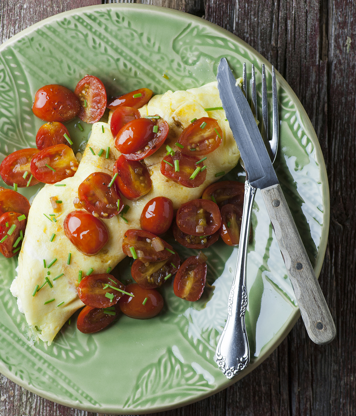 Ricotta omelet on a plate with a knife and fork.