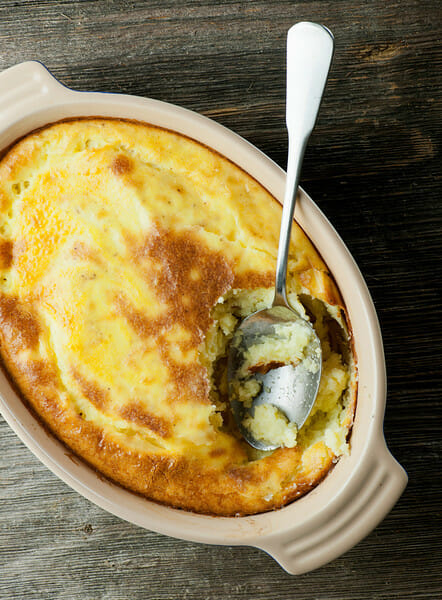 Baked Mashed Potatoes in a casserole with a spoon.