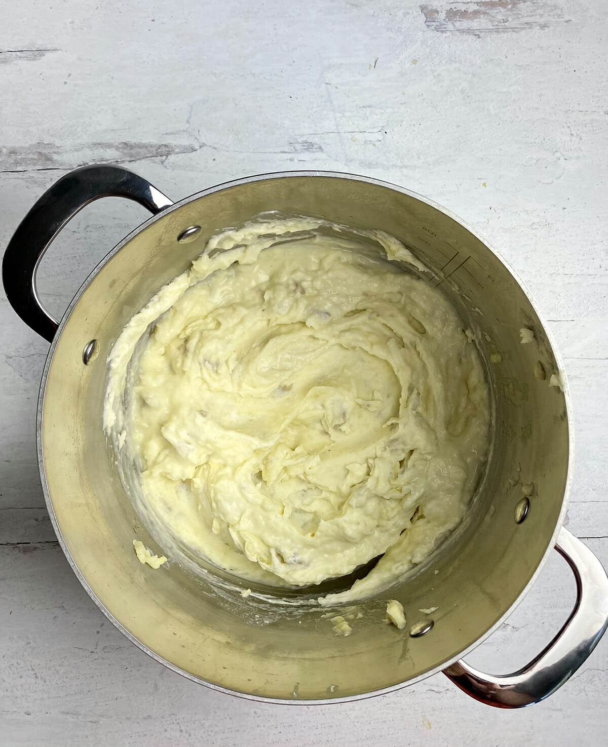 Mashed potatoes with butter and cream cheese in a pot.