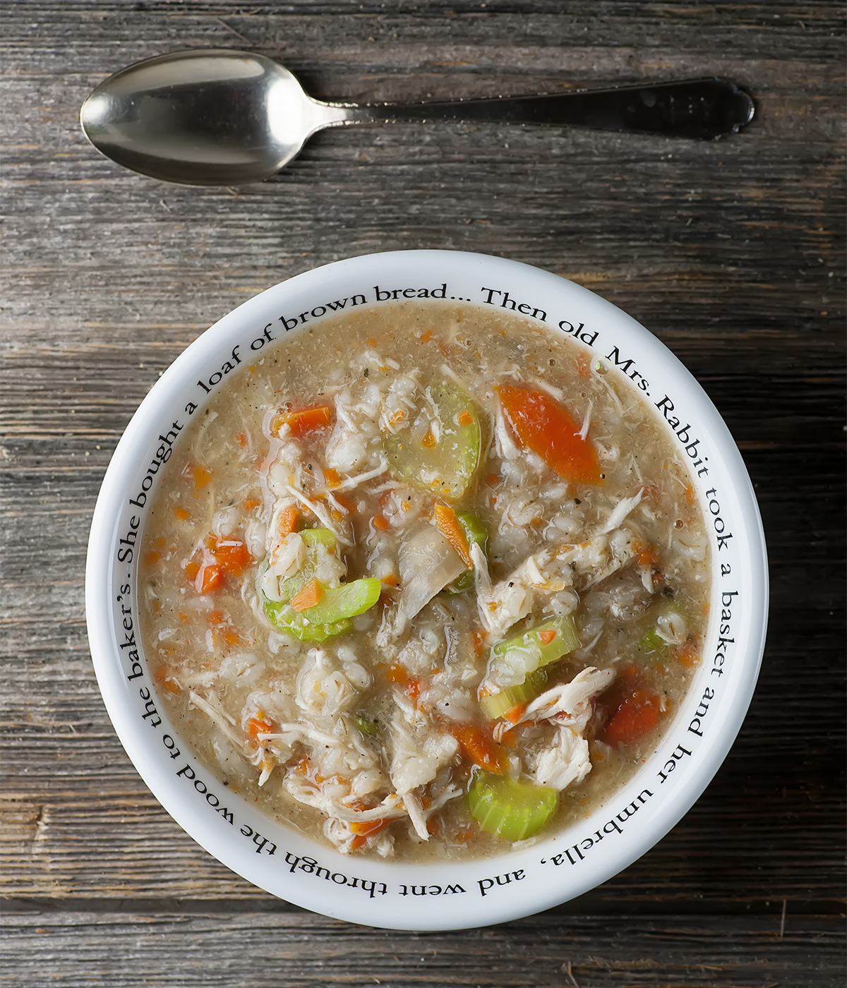 Chicken barley soup in a bowl with a spoon.