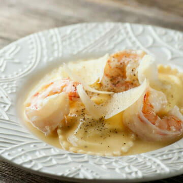 Shrimp Scampi Ravioli on a white plate.