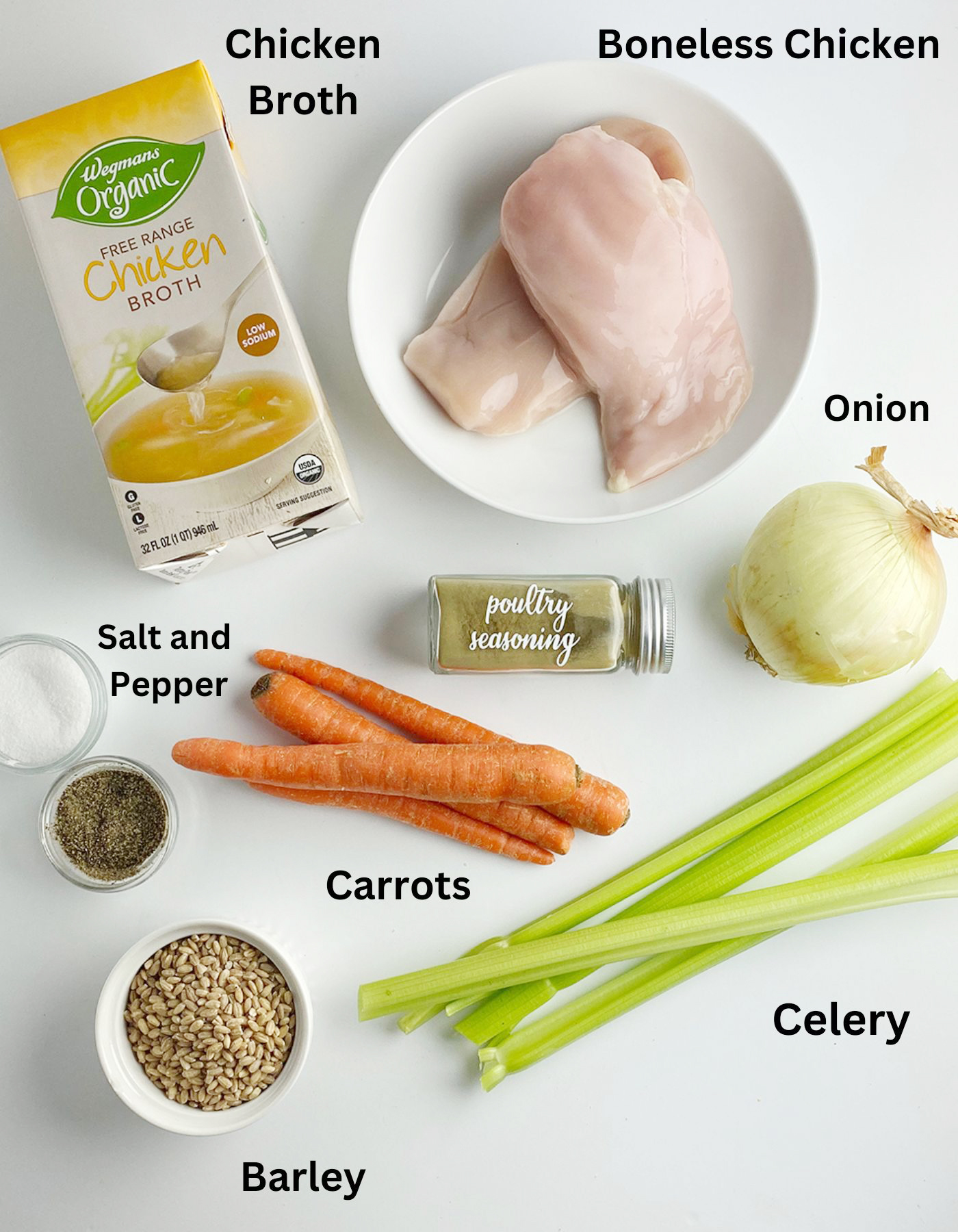 Ingredients for slow cooker chicken barley soup on a white counter.