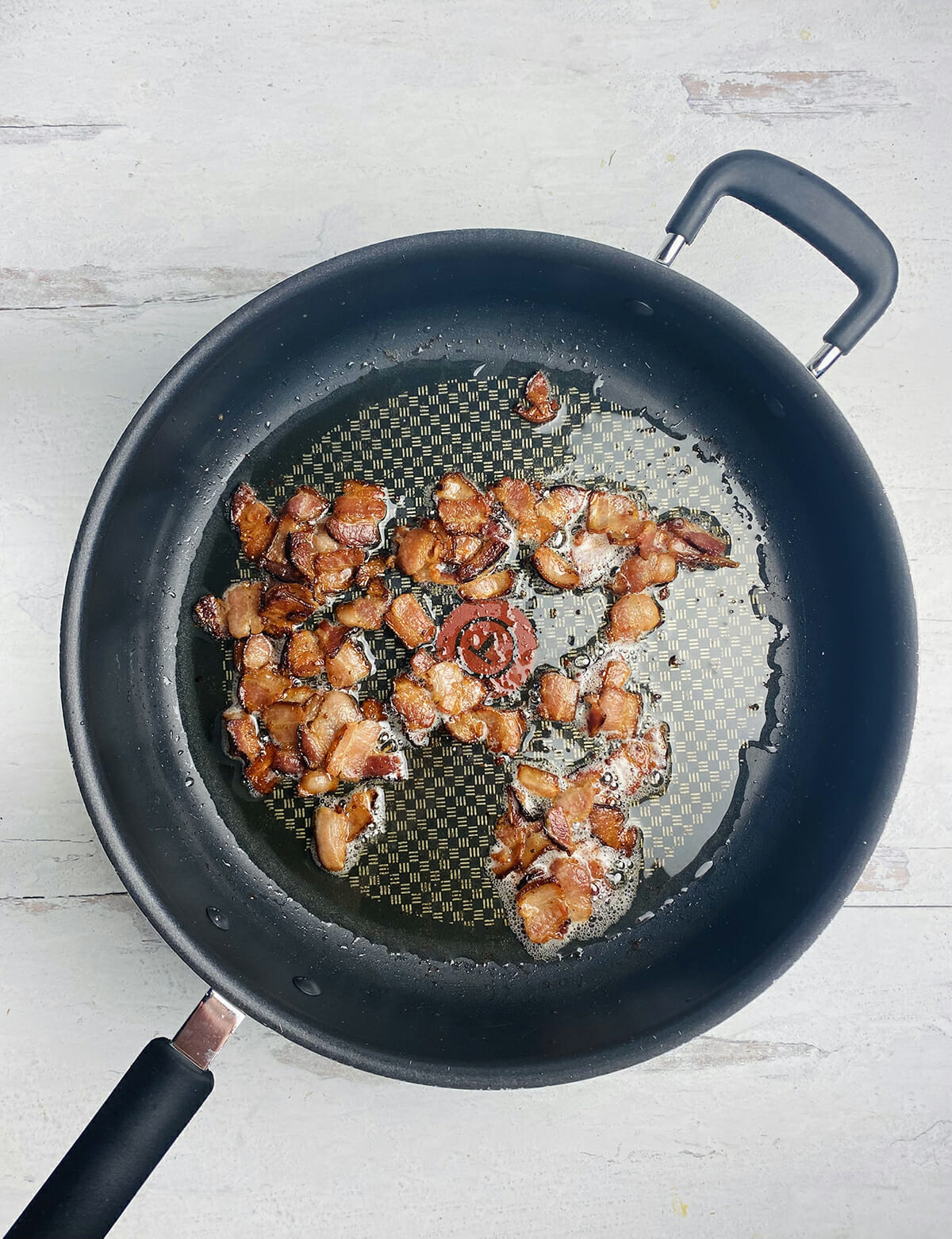 Chopped cooked bacon in a skillet.