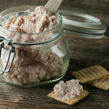 Deviled ham spread in a jar with crackers on the side.