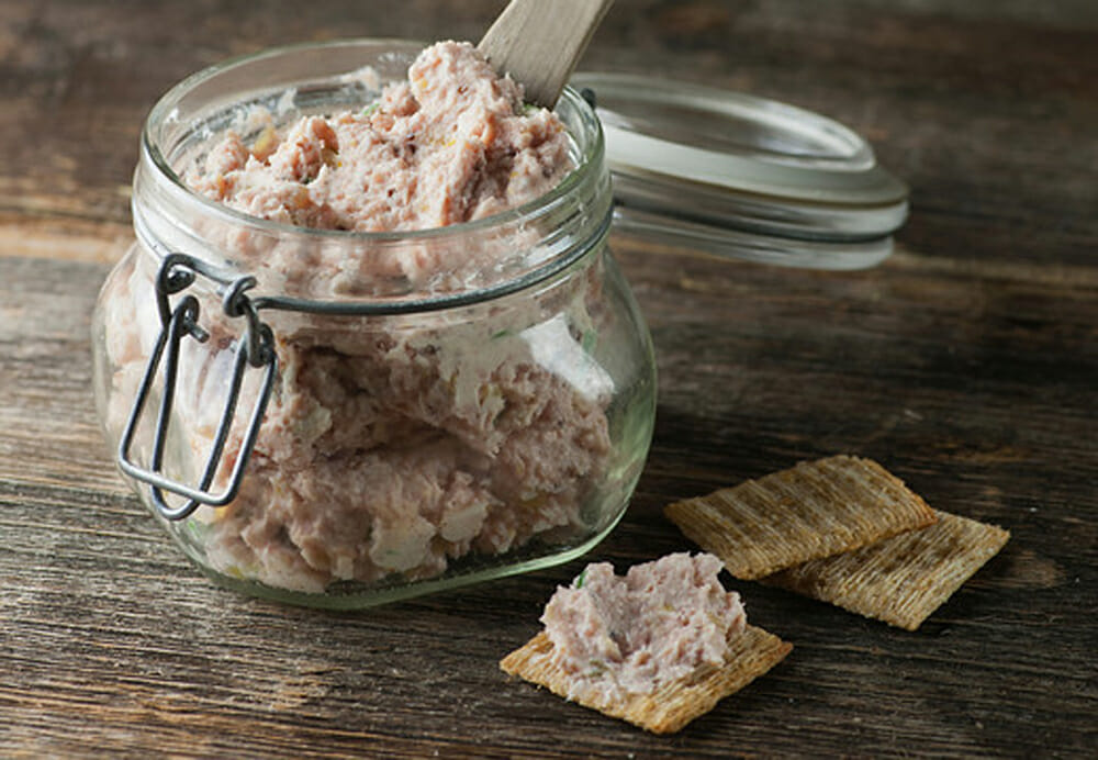 Deviled ham spread in a jar with crackers on the side.