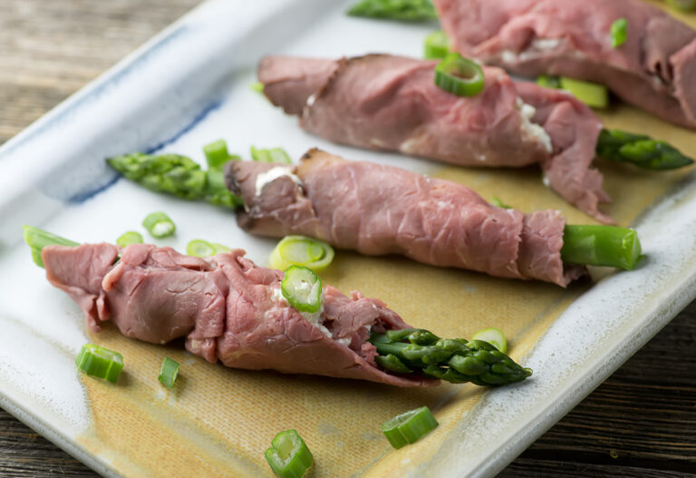 Roast beef rolls on a platter.