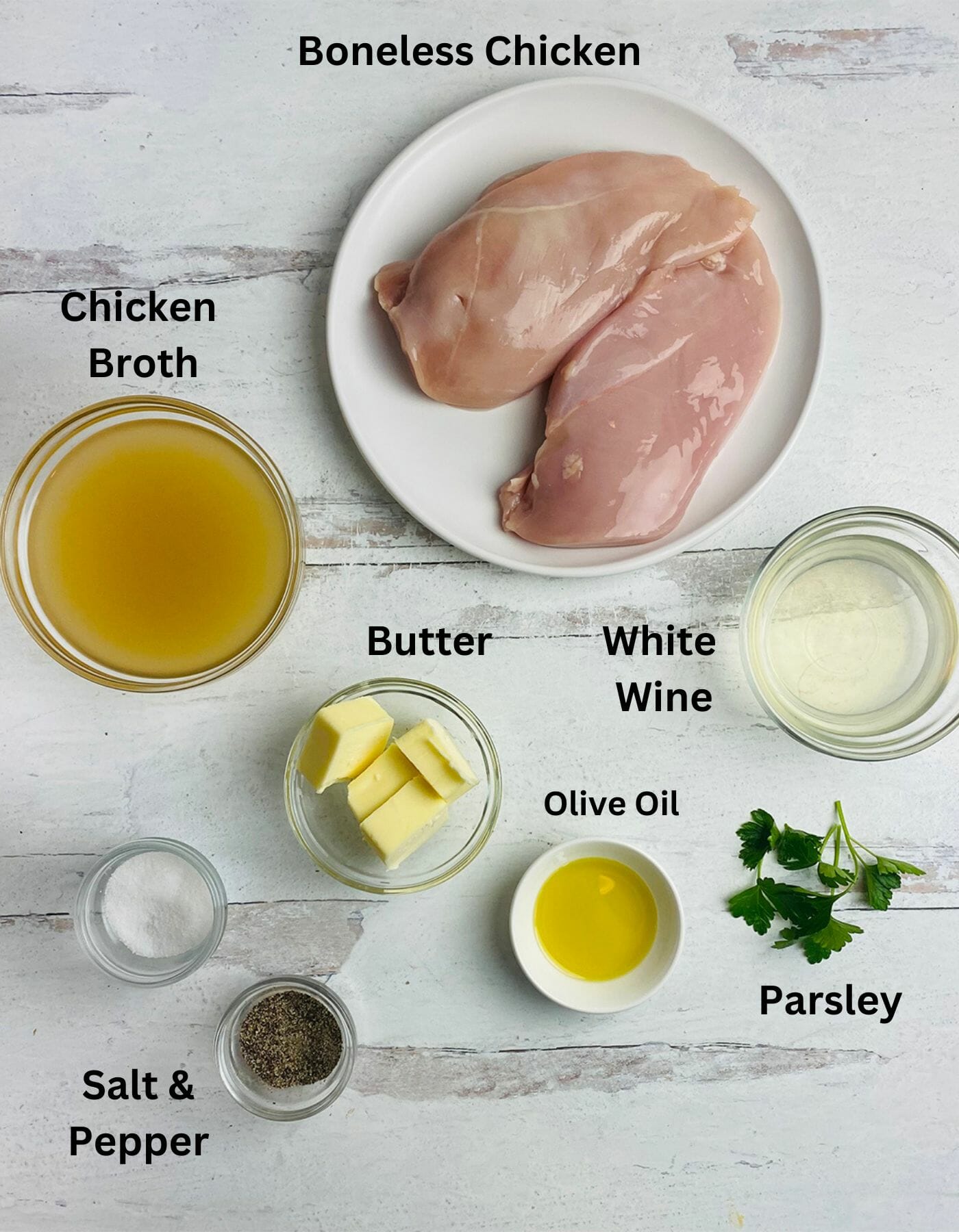 Ingredients for chicken in wine sauce on a wooden counter.