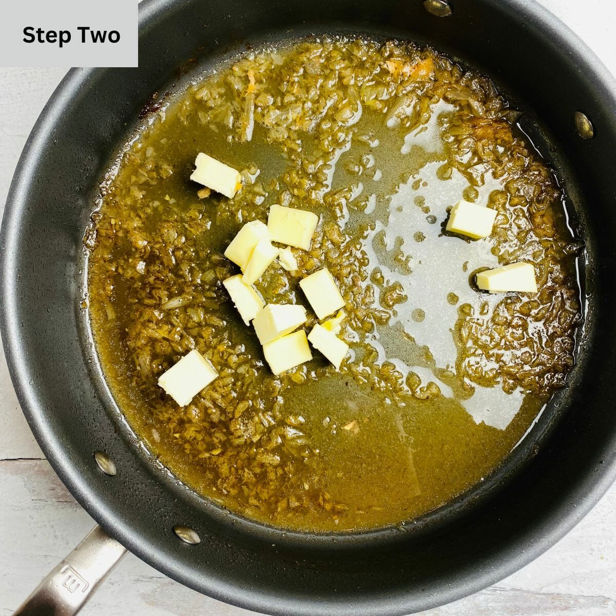 Butter and white wine sauce in a skillet.