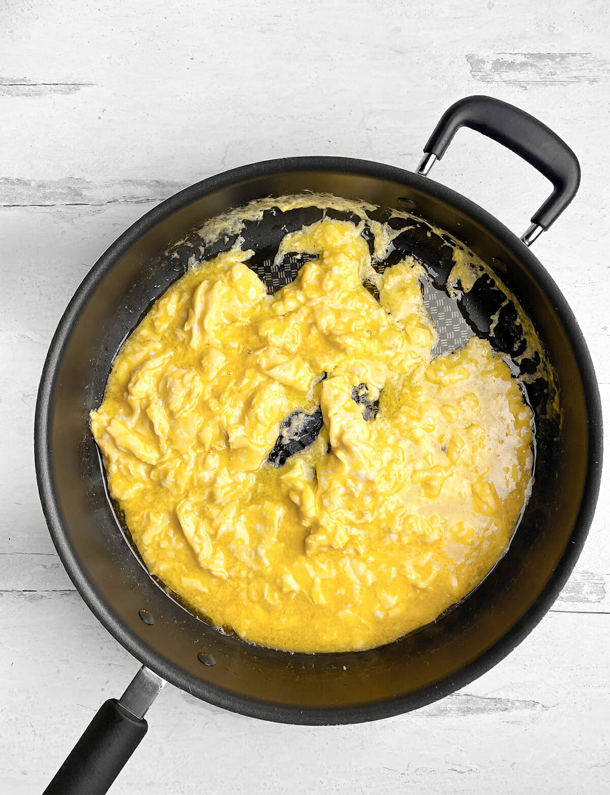 Softly scrambled eggs in a pan.