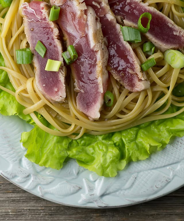 Grilled tuna with sesame noodles on a plate.