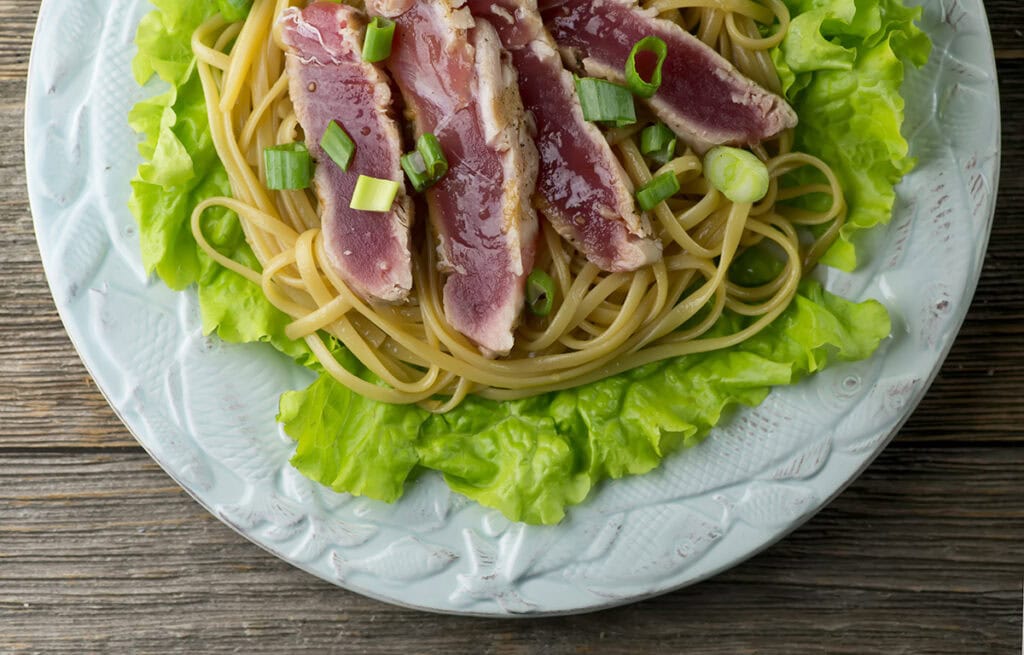 Grilled tuna with sesame noodles on a plate.