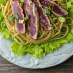 Grilled tuna with sesame noodles on a plate.