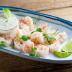 Shrimp with lime dipping sauce on a platter.