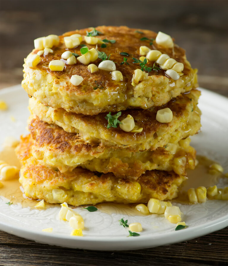 Stack of fresh corn johnny cakes on a plate.