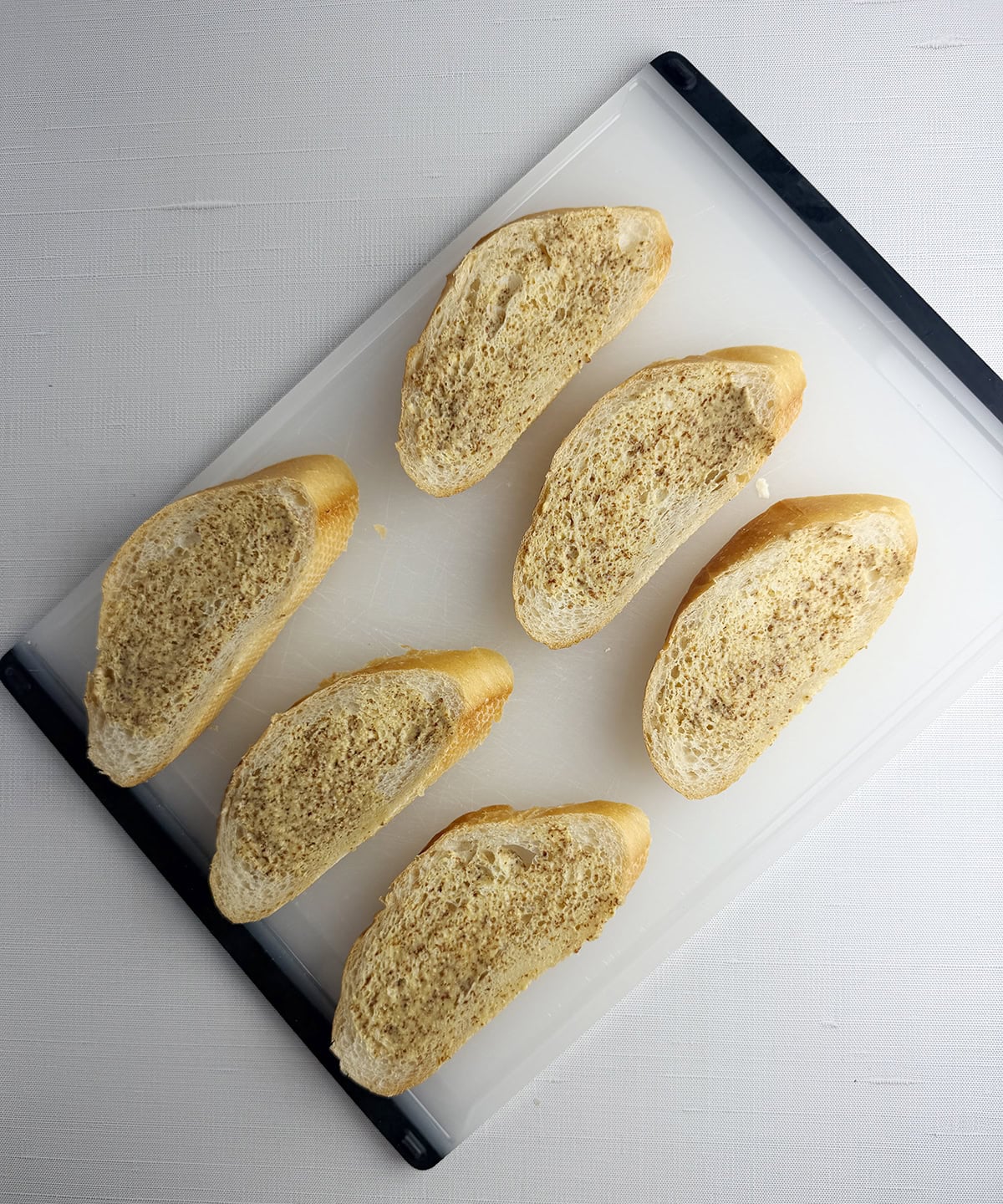 Bread slices spread with mustard.