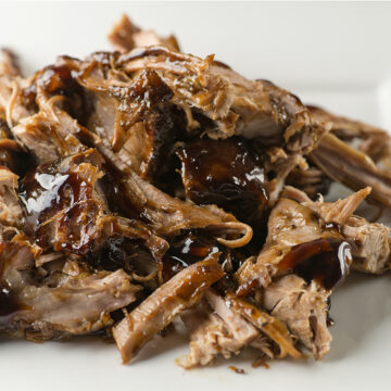 Pile of slow cooker brown sugar pulled pork on a plate.