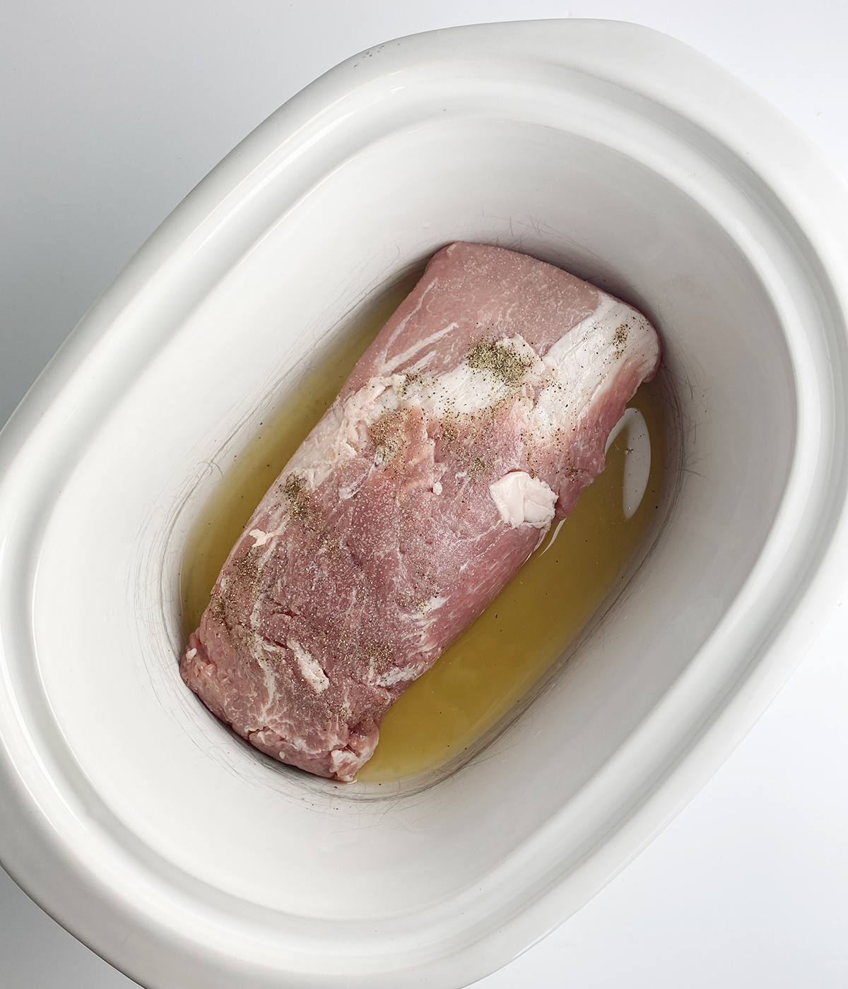 Pork roast and chicken broth in a slow cooker.