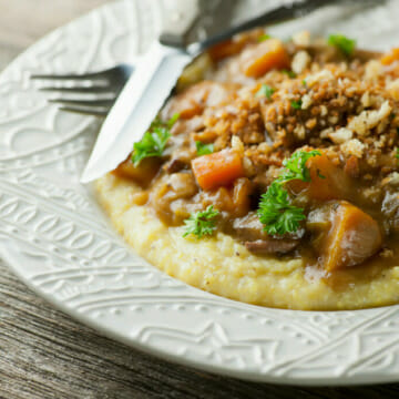 Slow cooker beef stew with breadcrumbs on a plate.