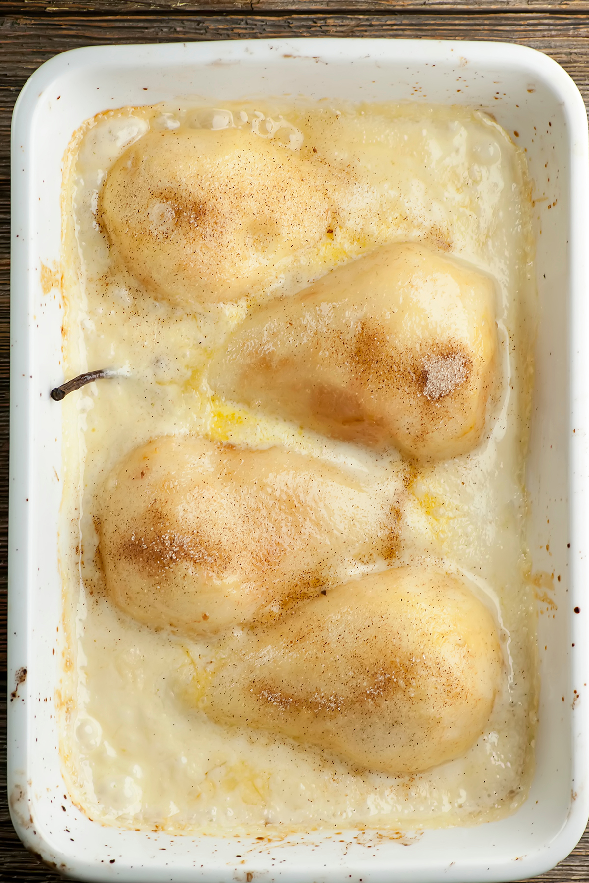 Baked pears in vanilla cream sauce ini a casserole dish.