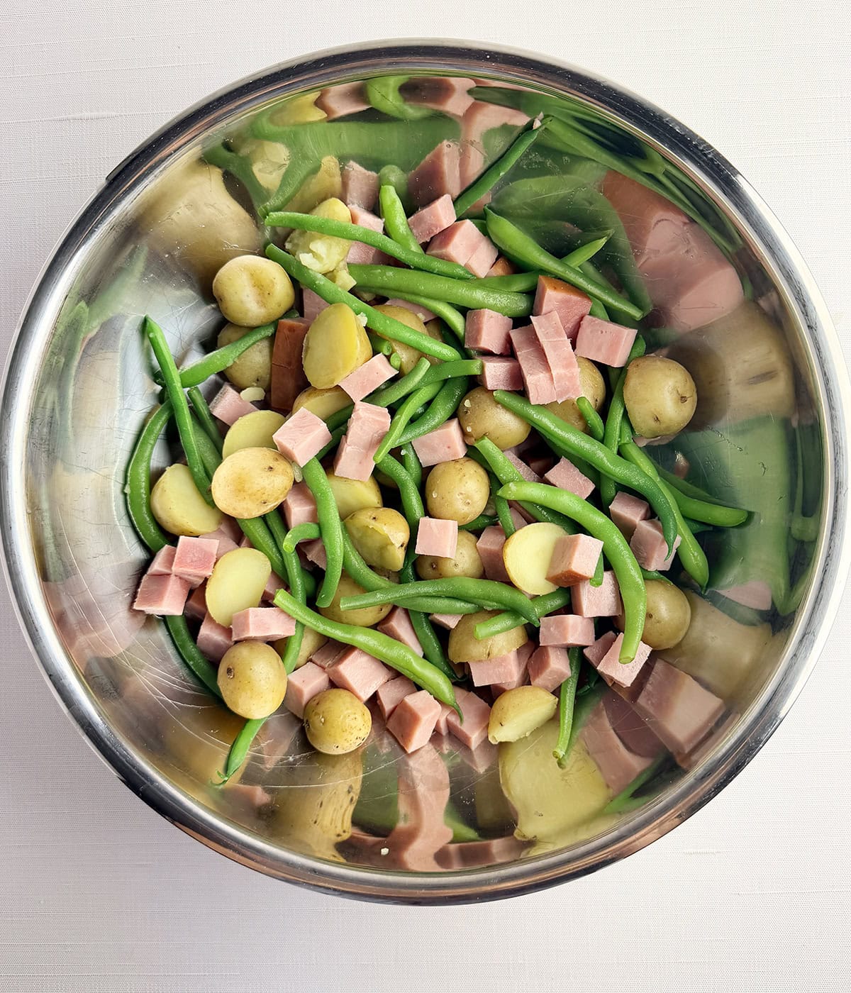 Ham green beans and potatoes in a mixing bowl.