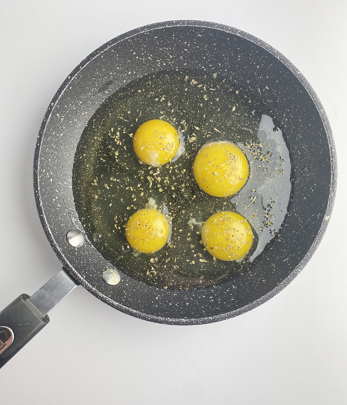 Eggs in a skillet with seasoning.