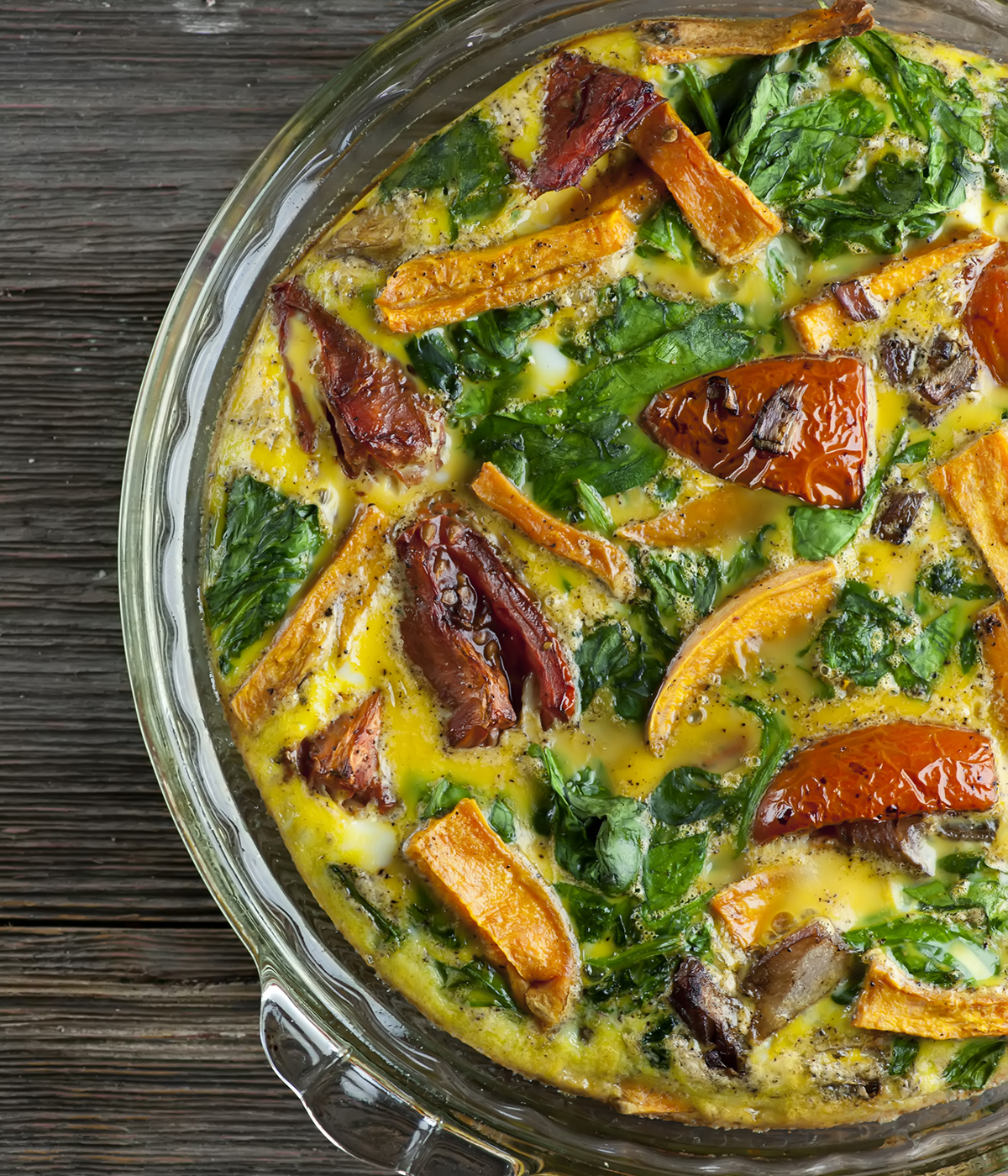 Baked vegetable frittata on a wooden counter.