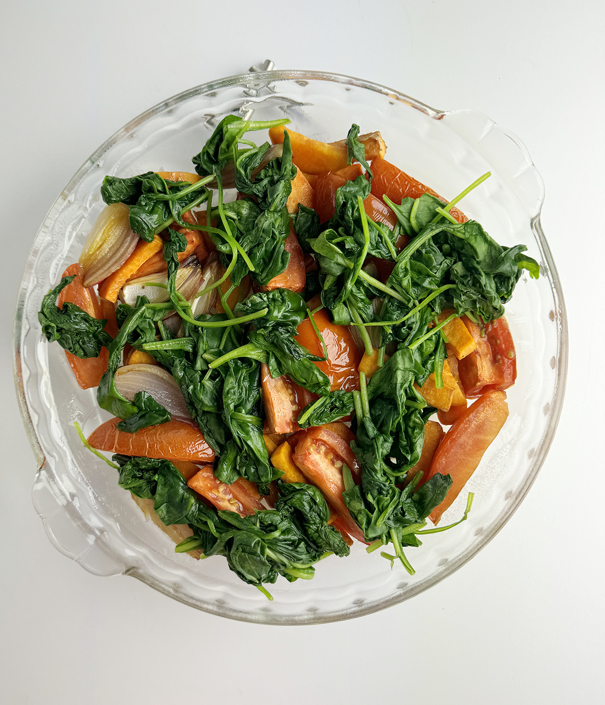 Cooked vegetables in a pie plate.