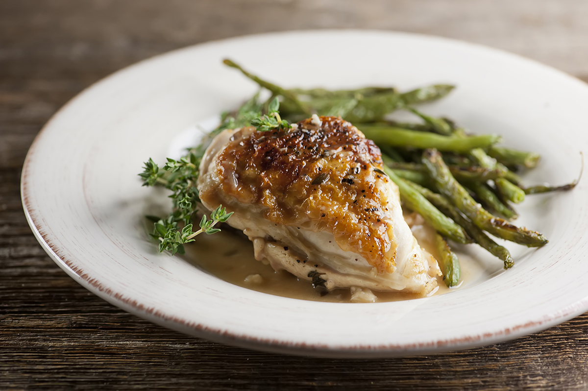 Chicken with white wine gravy on a plate.