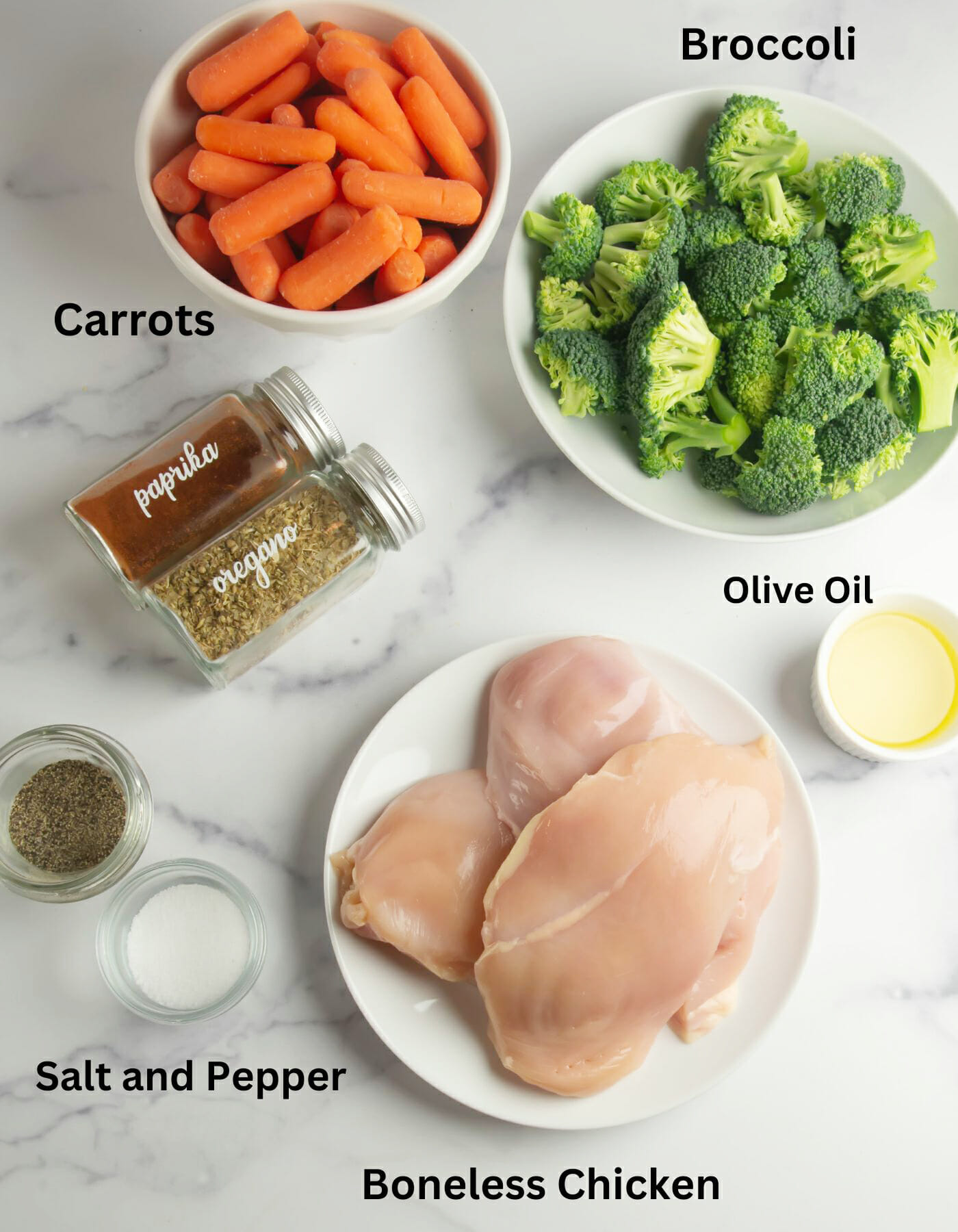 One pan roasted chicken and vegetables ingredients on a marble counter.