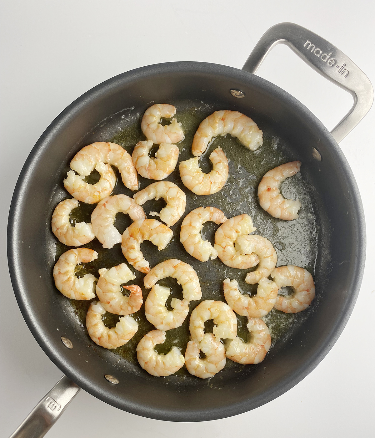 Shrimp cooking in a skillet.