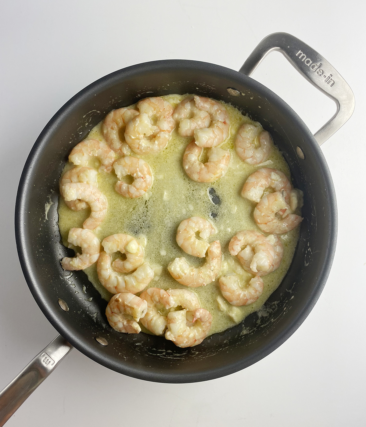 Shrimp in blue cheese sauce in a skillet.